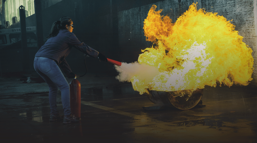 Esercitazione pratica di spegnimento di un fuoco con estintore durante un corso antincendio